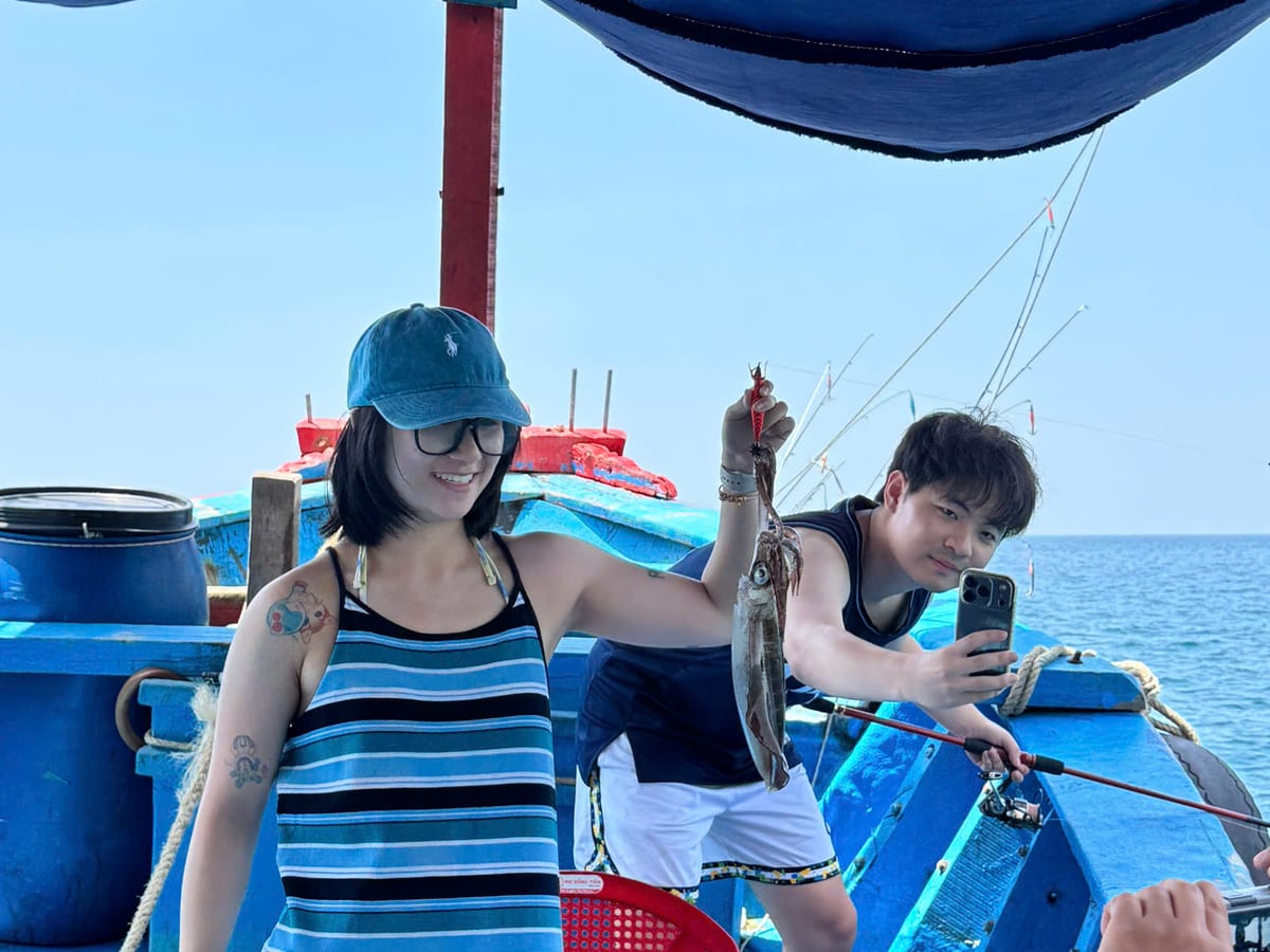 Two guests fishing under the boat canopy on an inshore day trip in Phu Quoc